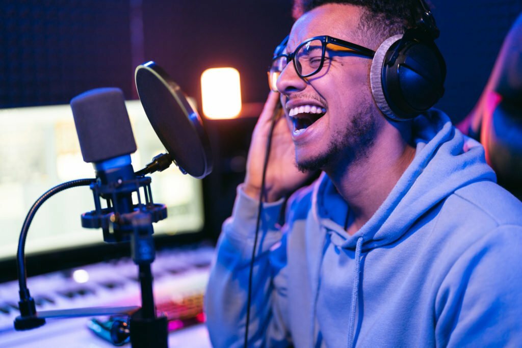 Young male singer in recording studio performing in neon lights